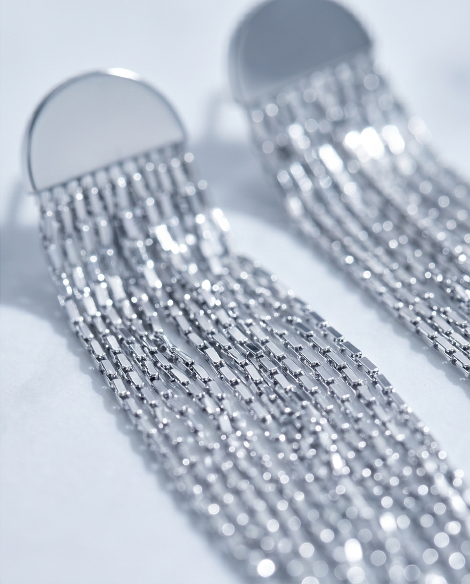 Close-up detail of silver box chain fringe and half moon stud