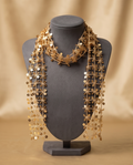 Gold sequin daisy mesh scarf choker necklace displayed on grey jewellery bust