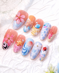 Summer Ocean press-on nails in clear display box on sand