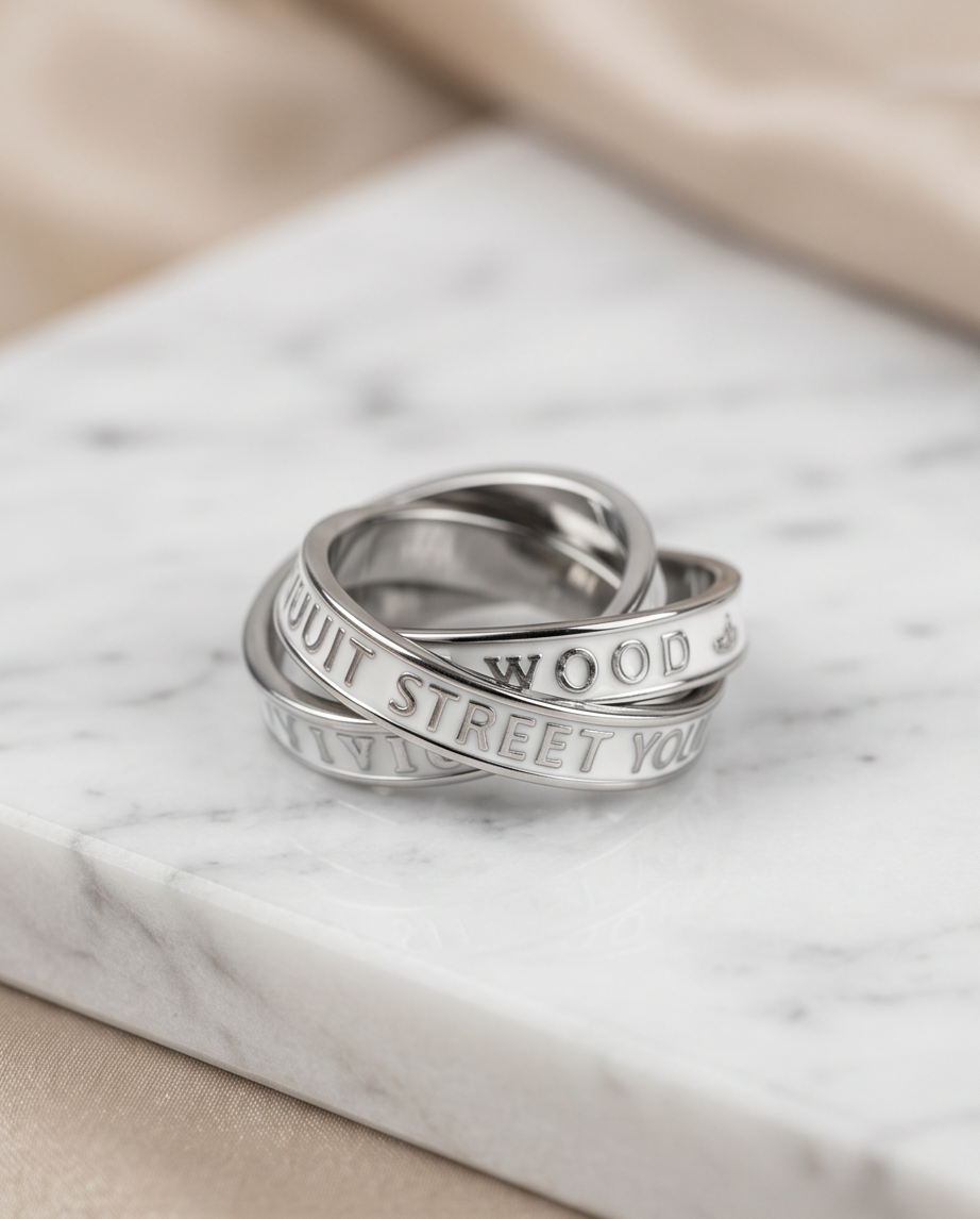 Silver triple interlocking text band ring on marble with cream silk