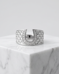 Silver crystal pavé horseshoe quilted ring on marble pedestal
