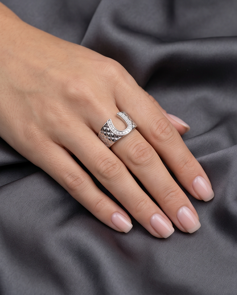 Close-up macro detail of crystal pavé horseshoe and quilted band