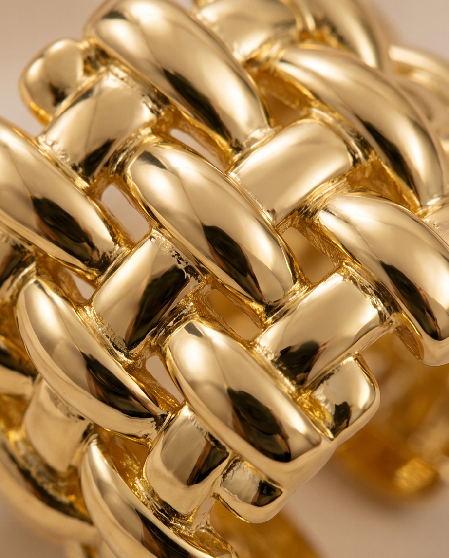 Gold Woven Basket Weave Wide Band Ring worn on model's hand over cream satin fabric