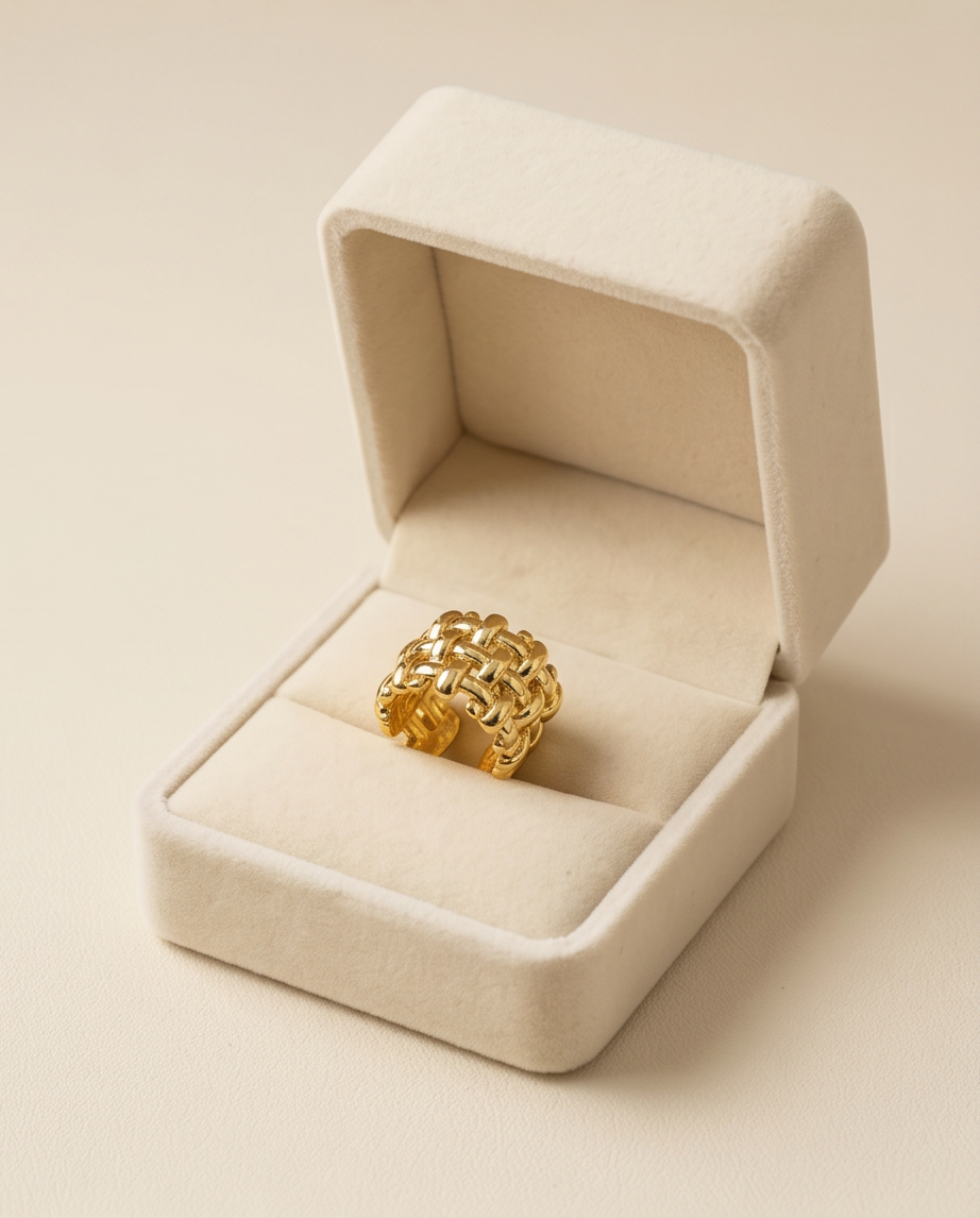 Gold Woven Basket Weave Wide Band Ring flat lay on white marble surface