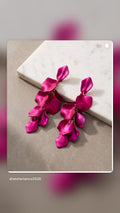 Fuchsia petal drop earrings on marble surface