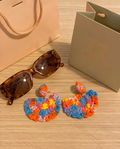 Rainbow crochet fan drop earrings flat lay with sunglasses and Wisteria & Co. gift bag