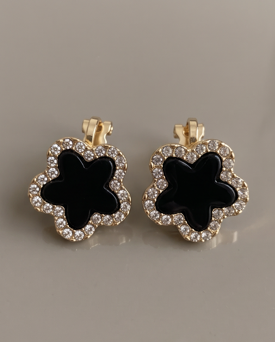 Black enamel clover crystal clip earrings - close-up detail