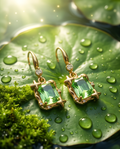 Macro close up of gold tone peridot green emerald-cut crystal star frame hook drop earring on white surface showing star detail and crystal clarity