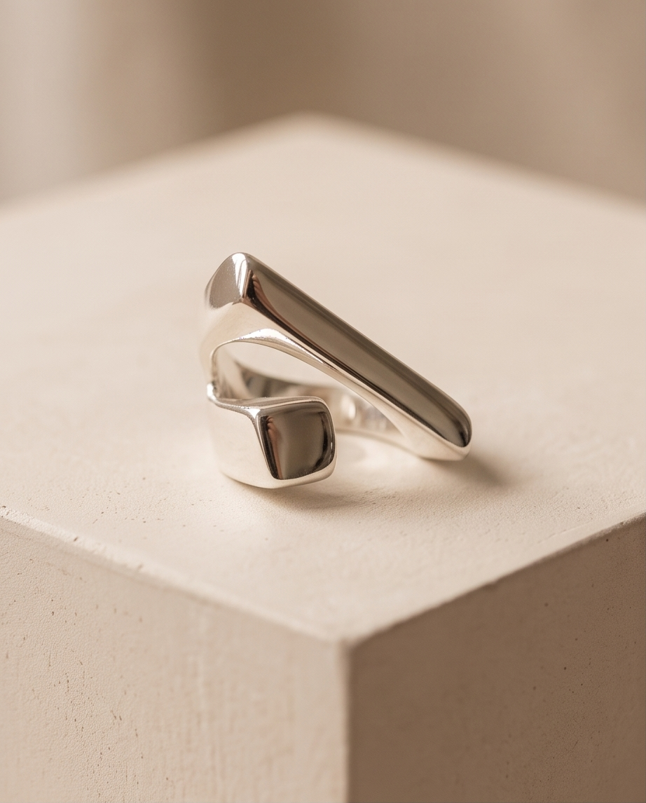 Macro close up of 925 silver plated high polish geometric bar and square signet wrap open adjustable ring showing mirror-finish elongated bar and square signet detail against warm beige background