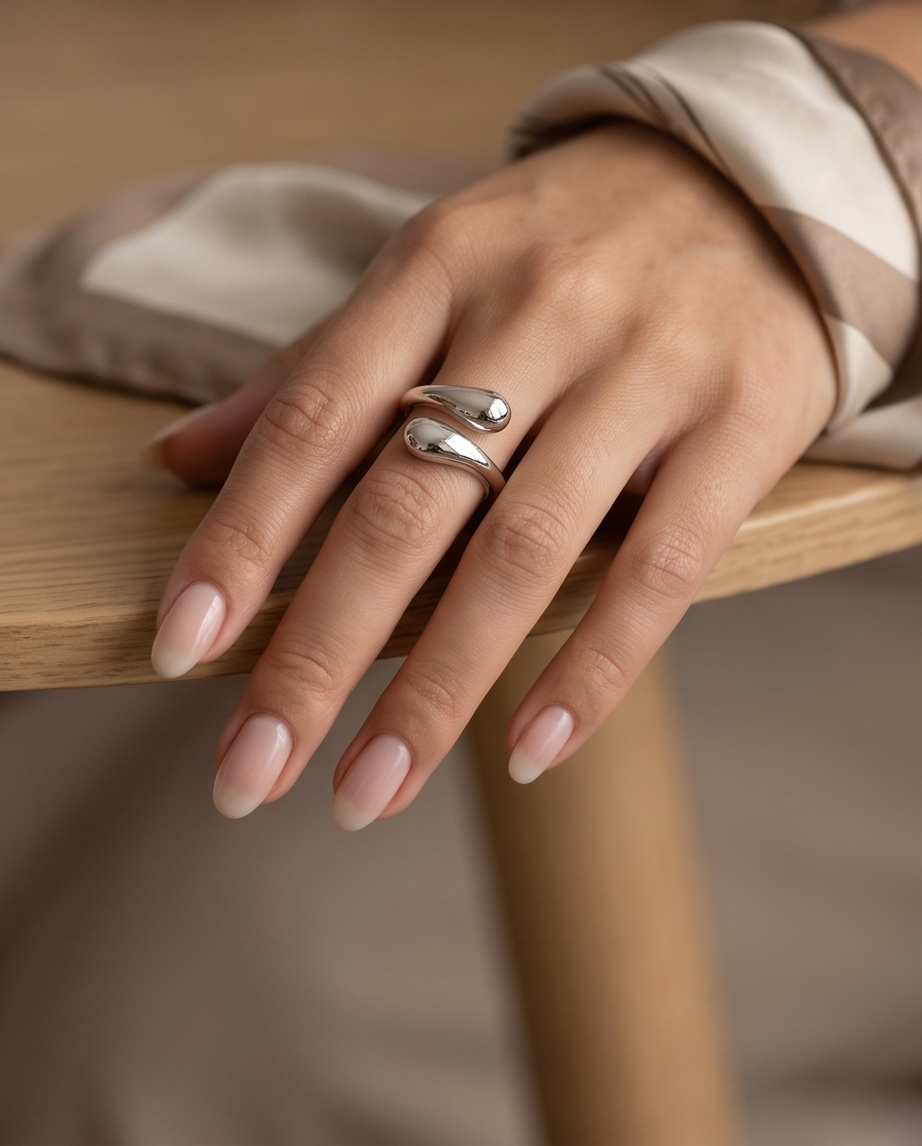 Macro close up of 925 silver plated sculptural double teardrop wrap open adjustable ring showing mirror-polish liquid silver finish on both teardrop forms