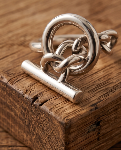 Macro close up of 925 silver plated high polish celtic love knot circle toggle bar open adjustable ring on rustic reclaimed wood block showing intricate knot weave and circle toggle detail