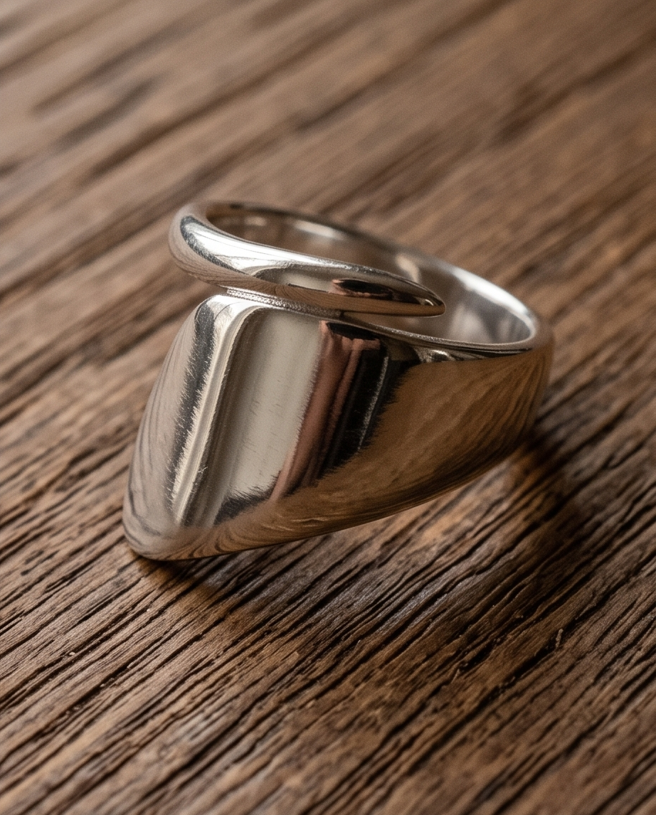 Macro close up of 925 silver plated high polish chunky cushion signet open adjustable ring on rustic reclaimed wood showing mirror-finish rounded square signet face and substantial band profile