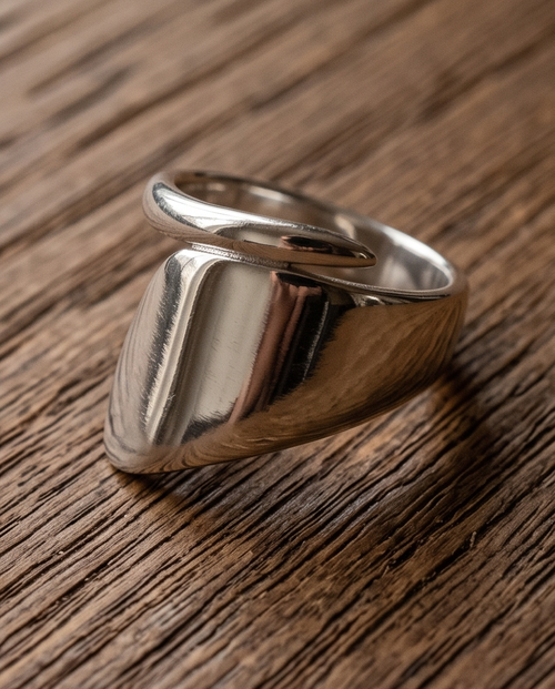 Macro close up of 925 silver plated high polish chunky cushion signet open adjustable ring on rustic reclaimed wood showing mirror-finish rounded square signet face and substantial band profile