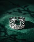 925 silver plated CZ pave horseshoe quilted wide cuff open adjustable ring on emerald green velvet with botanical leaf shadow and star burst light reflections from CZ stones — luxury dark editorial