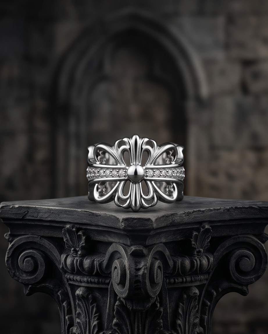 Silver plated gothic fleur de lis baroque cross CZ pave band open adjustable ring standing on ornate dark carved stone column capital in front of gothic cathedral arch — dark luxury editorial product shot