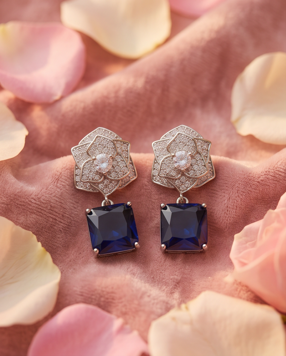 Sapphire Rose Pavé Drop Earrings - both earrings cupped in hand surrounded by pink and cream rose petals