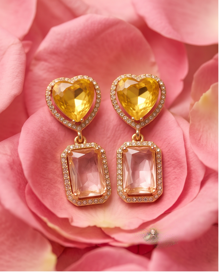 Citrine Heart & Rose Quartz Drop Earrings - both earrings laid flat on pink rose petals