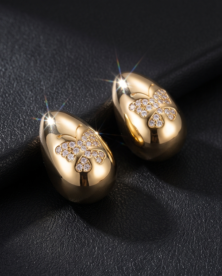 Gold Puffed Teardrop Butterfly Pavé Earrings - both earrings on black satin fabric with light sparkle flares