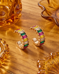 Close-up of gold rainbow baguette crystal hoop earring showing emerald, ruby, yellow and clear crystal baguettes