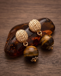Gold Ribbed Dome Tiger's Eye Ball Drop Earrings pair resting on amber stone surface