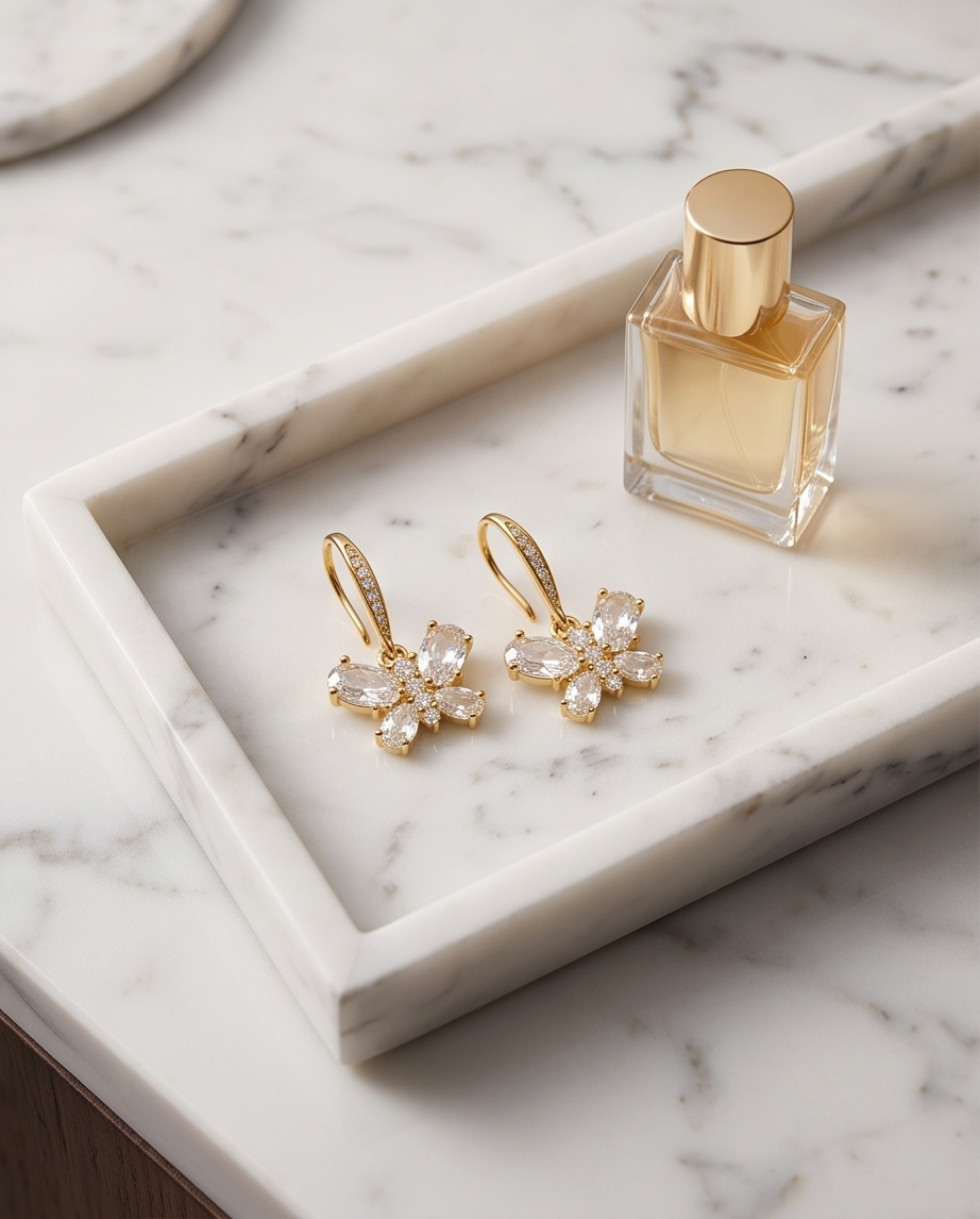 Gold crystal butterfly pave hook drop earrings on a marble ledge