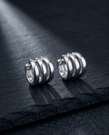 Silver triple band chunky hoop earrings on black slate product shot