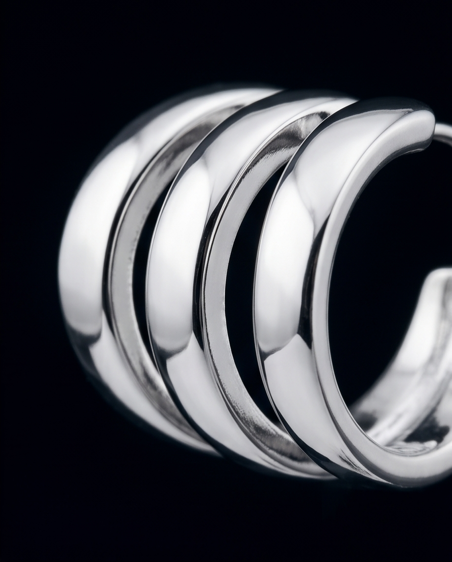 Silver triple band hoop earring close-up on black background