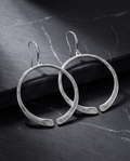 Silver brushed open circle drop earrings on black marble