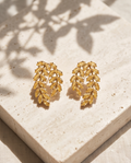 Gold citrine crystal leaf cluster stud earrings on travertine stone
