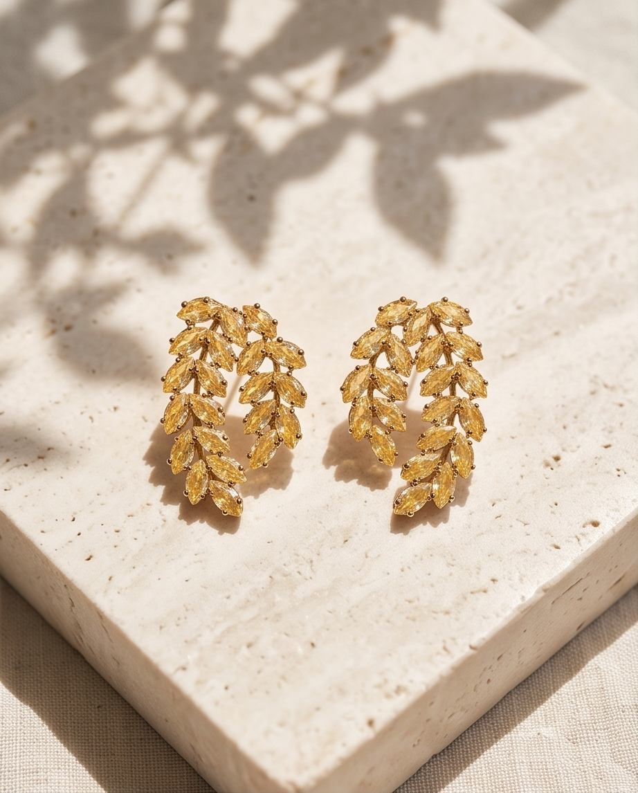 Gold citrine crystal leaf cluster stud earrings on travertine stone