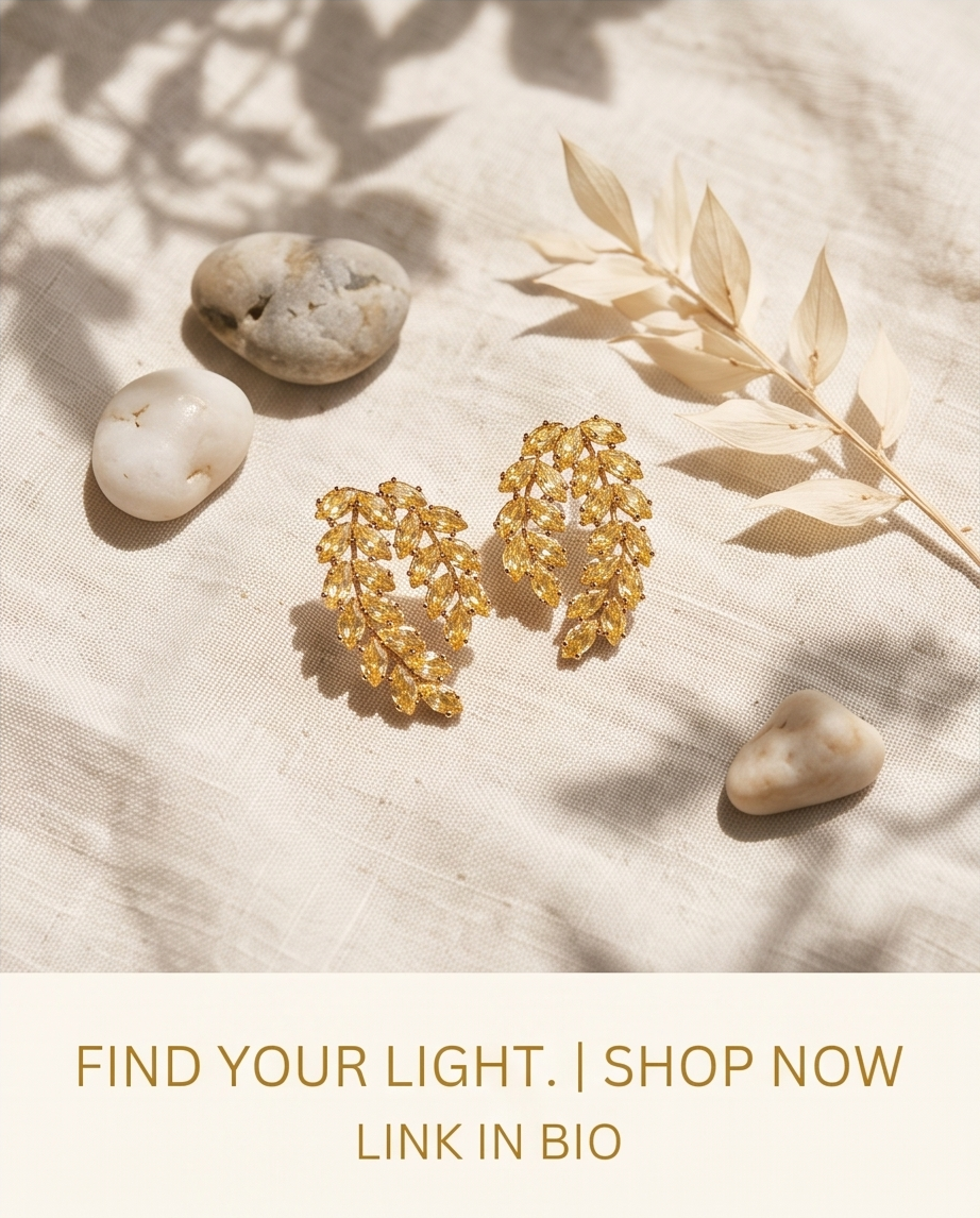 Gold citrine crystal leaf earrings styled on linen