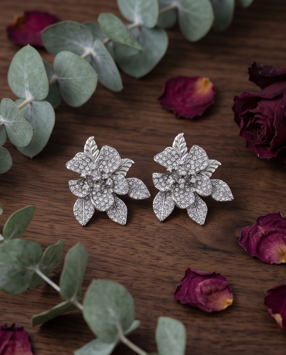 Silver crystal pave orchid statement stud earrings on dark wood
