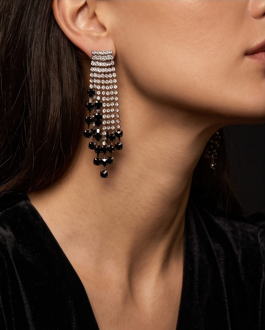 Crystal and jet fringe earrings displayed on mirrored glass