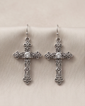 Antique silver gothic cross drop earrings, pair on cream fabric
