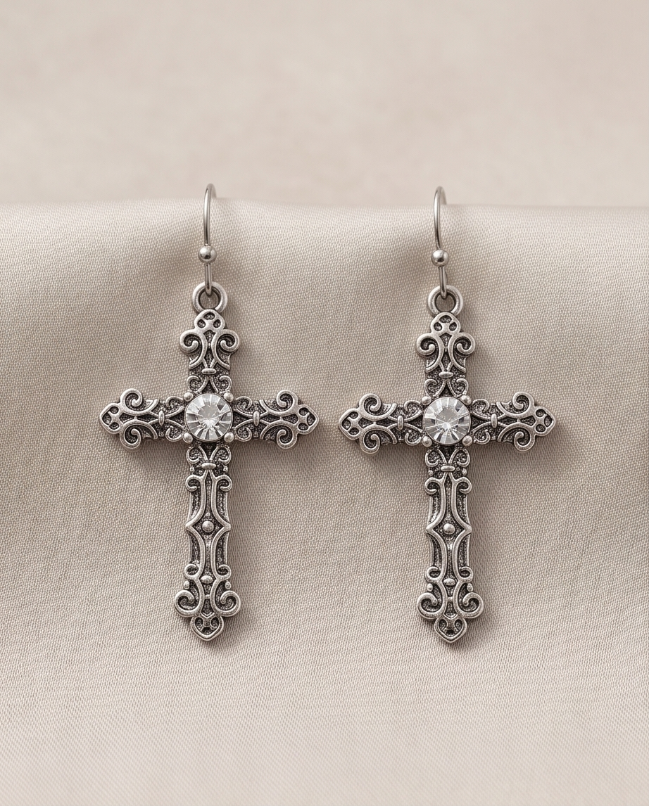 Antique silver gothic cross drop earrings, pair on cream fabric