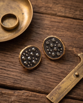 Macro detail of dark hematite pavé crystals and hammered gold rim