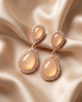 Model wearing peach-toned double teardrop earrings