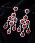 Pair of ruby-red chandelier earrings on a dark background