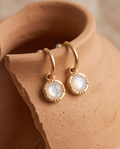 Close-up of round pearl-look pendant and gold-tone frame