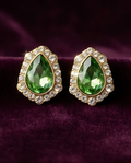Close-up of green teardrop earring with clear-stone halo