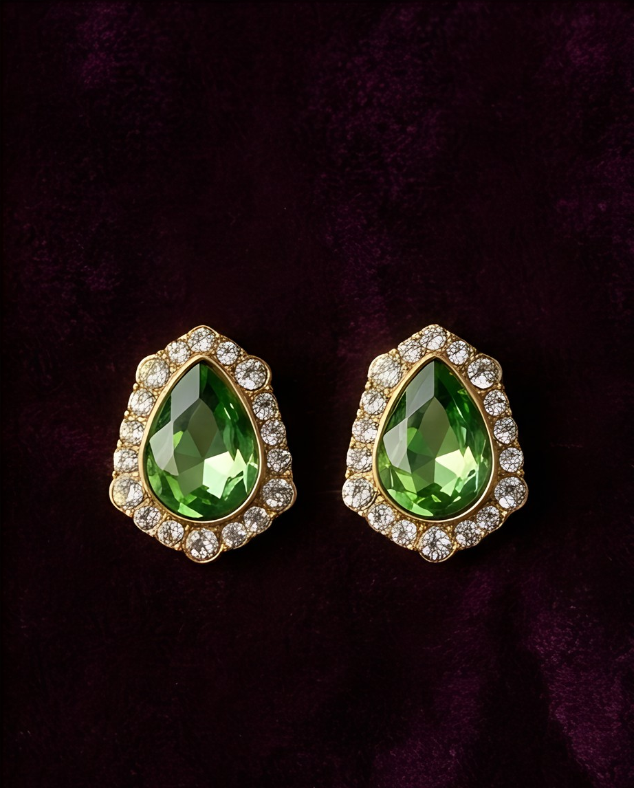 Pair of green teardrop halo earrings on purple velvet