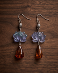 Lilac flower and translucent amber-effect pendant earring close-up