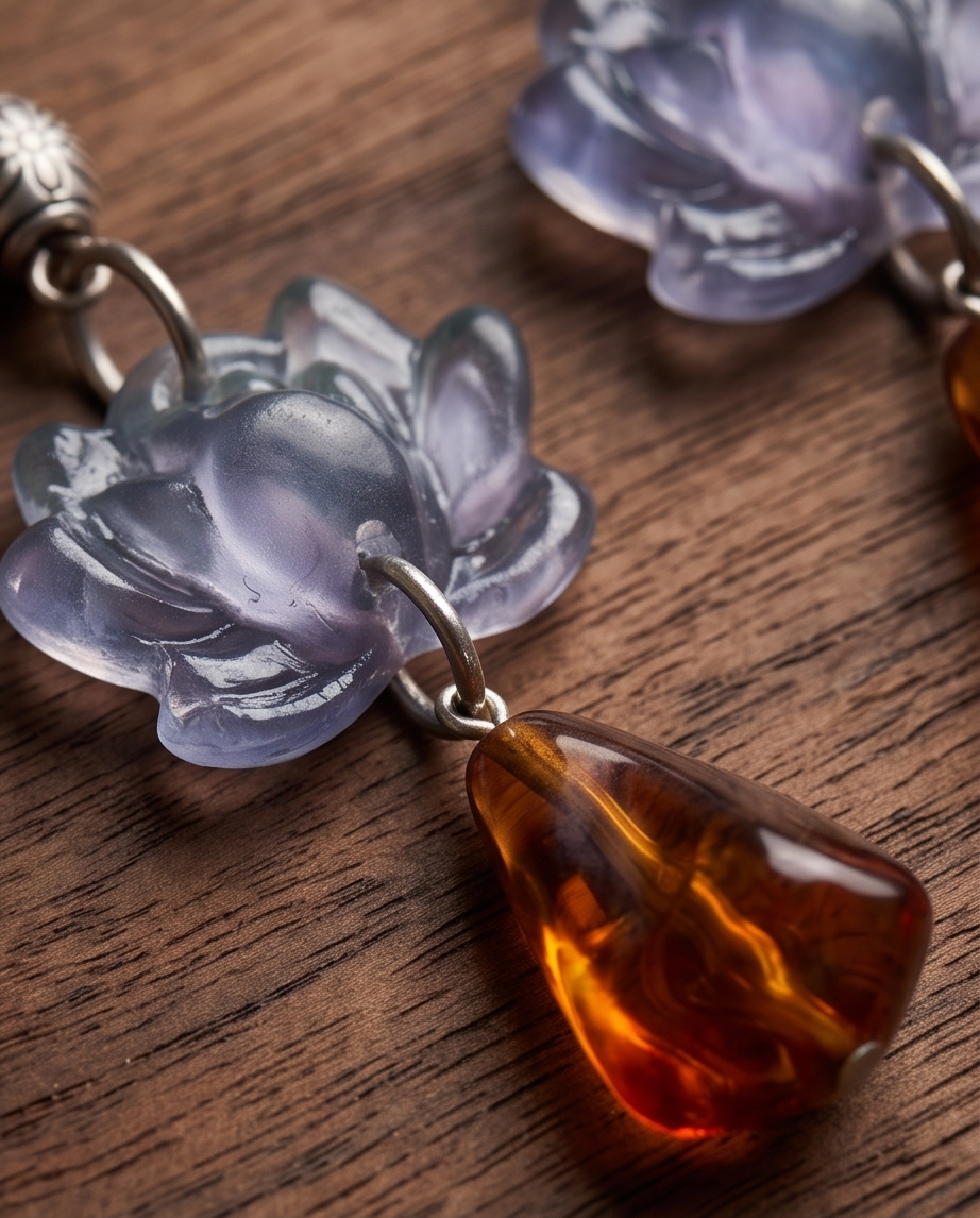 Pair of lilac lotus and amber-effect drop earrings with hook fastenings on wood