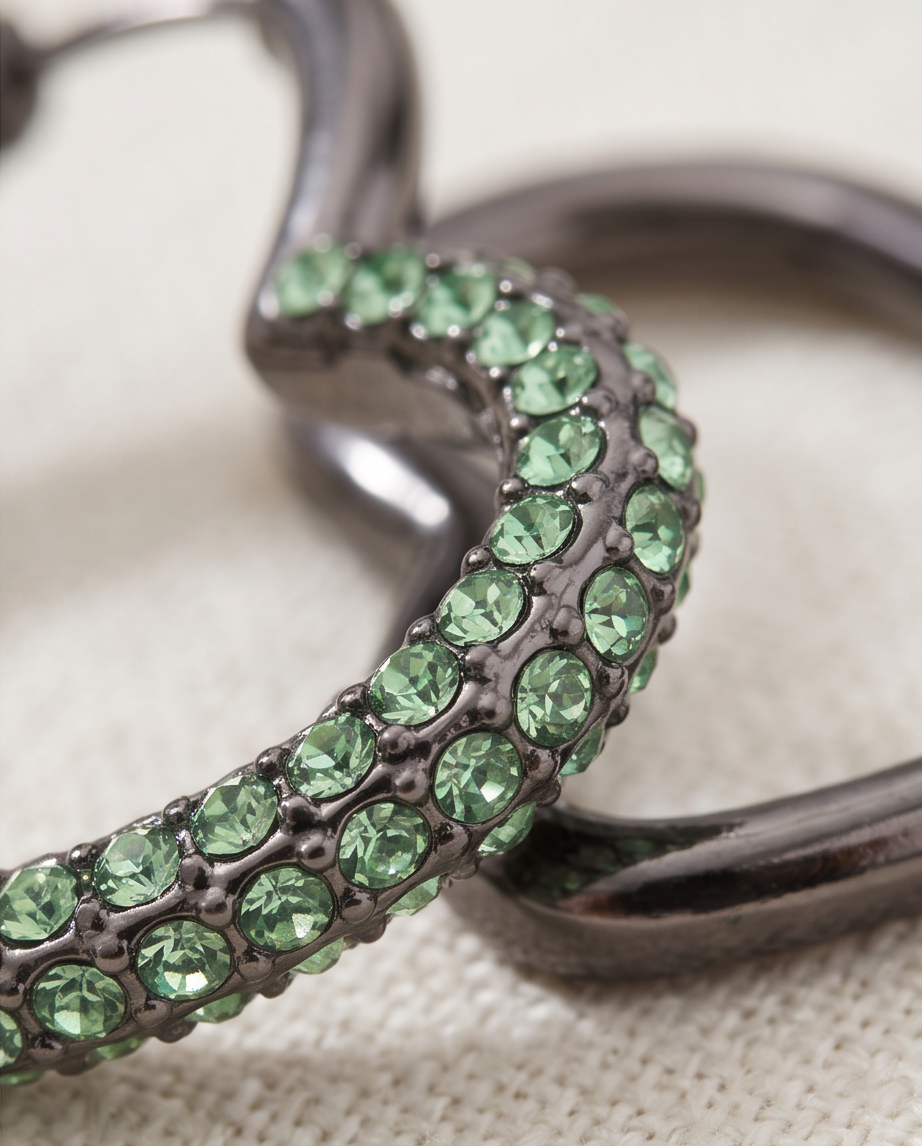 Model wearing green crystal heart hoop earrings with a black outfit