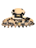 Beige and black spotted hair clip on a white background