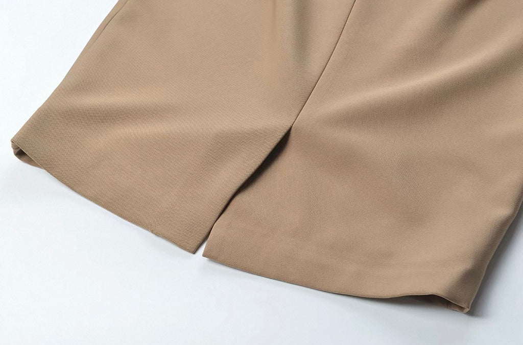 Close-up of a beige fabric garment, showing the texture and a fold detail on a white background.