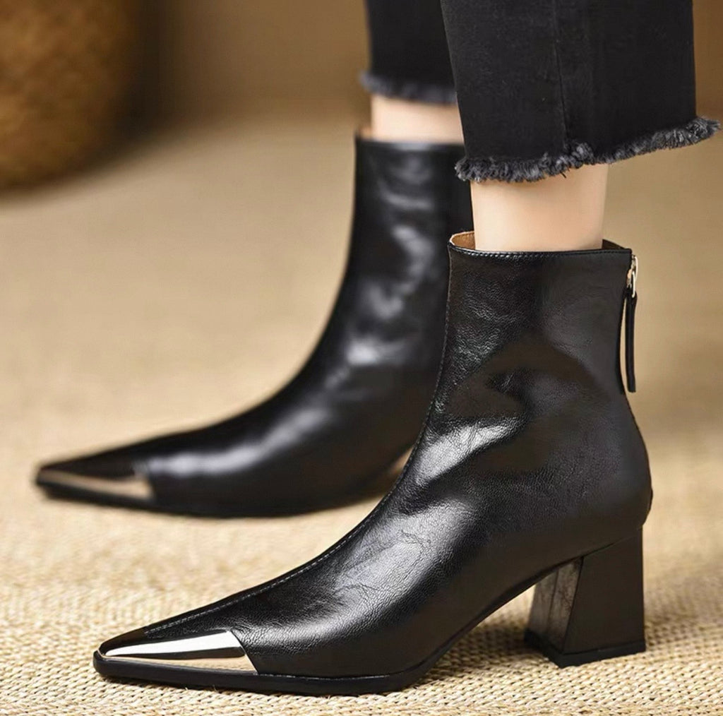 Black genuine leather metal cap-toe ankle boot — pair on floor, front view