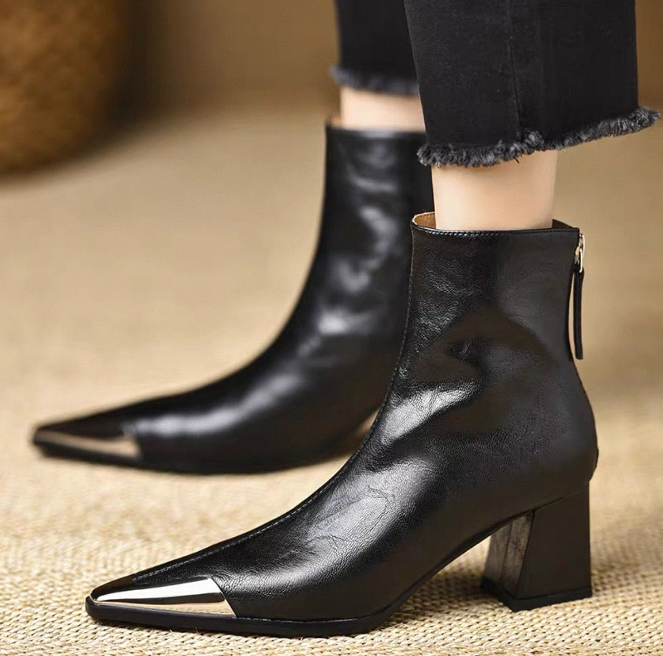 Black genuine leather metal cap-toe ankle boot — pair on floor, front view