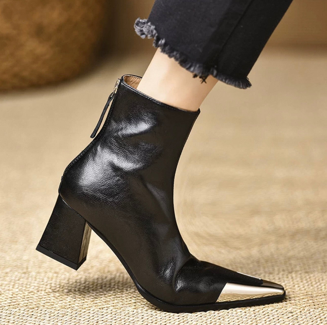 Black genuine leather metal cap-toe ankle boot — close-up of metal toe cap detail