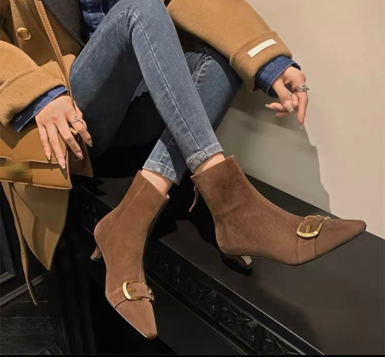 Brown suede gold buckle pointed-toe ankle boots on model